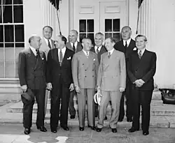 At the White House, Front row, left to right: Barney Balaban, Paramount; Harry Cohn, Columbia Pictures; Nicholas M. Schenck, Lowe's; Will H. Hays, and Leo Spitz, RKO. artists; Sidney Kent, 20th Century Fox; N.J. Blumberg, Universal; and Albert Warner, Warner Bros. in 1938